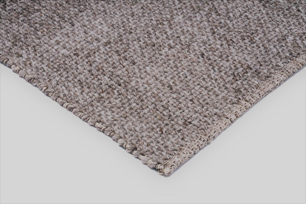 Close up shot of a Natural wool flat weave rug suitable for dining and living spaces