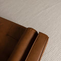 Brown leather sofa corner on a textured beige carpet