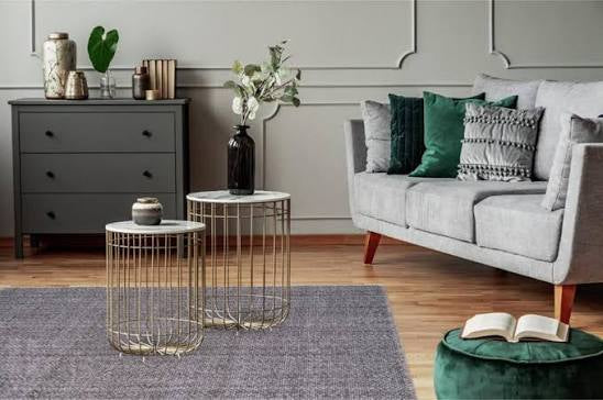 Low pile wool rug ideal for apartments and high traffic areas shown on a living room with a grey lounge on a timber flooring with green highligghts cushions.